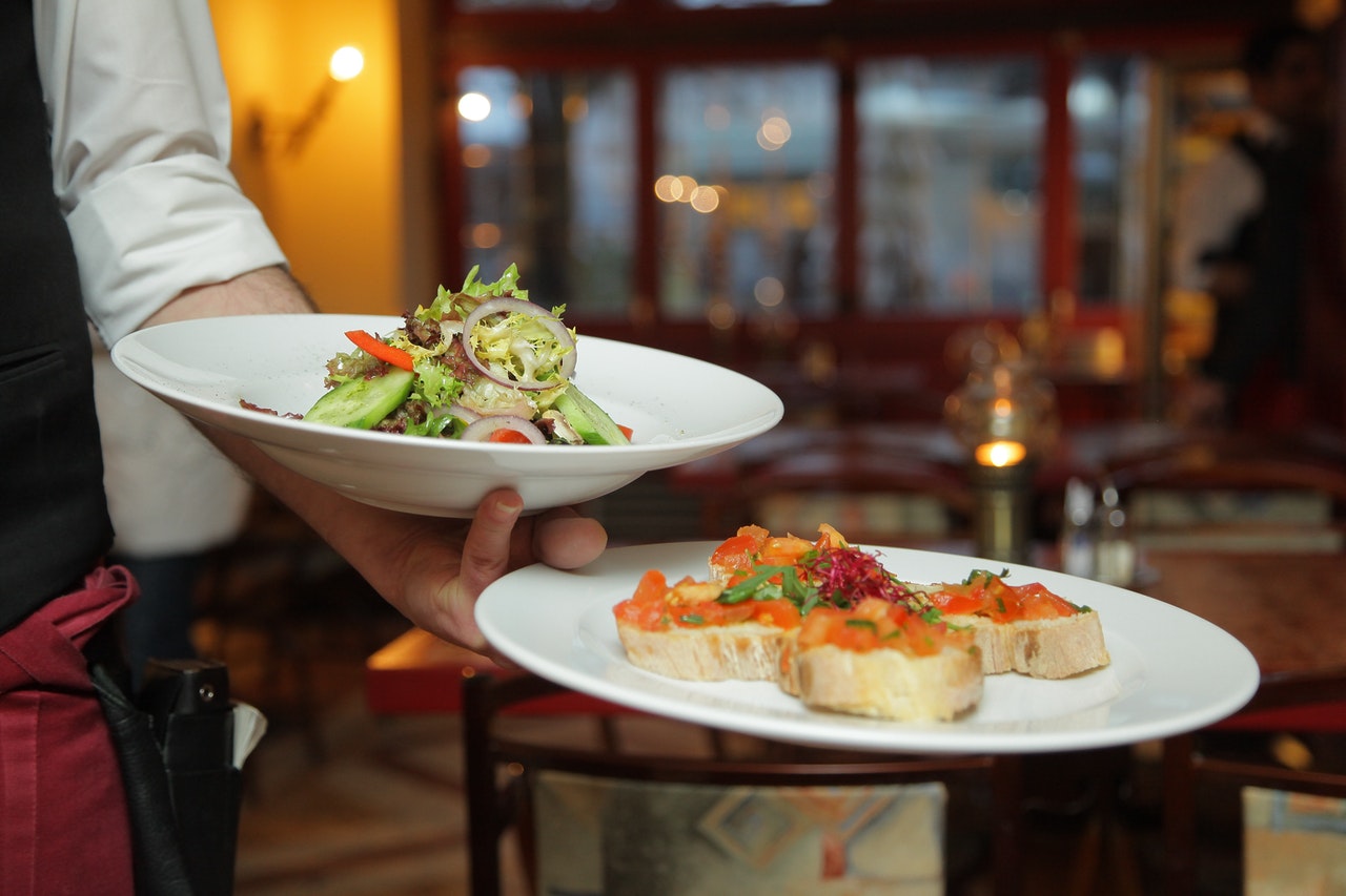 waiter carrying dishes in a restaurant using beautiful restaurant design